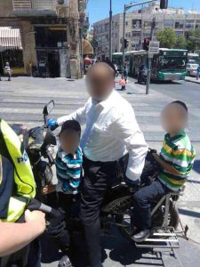 אב מרכיב את שני ילדיו על אופניים חשמליים (צילום: דוברות המשטרה)
