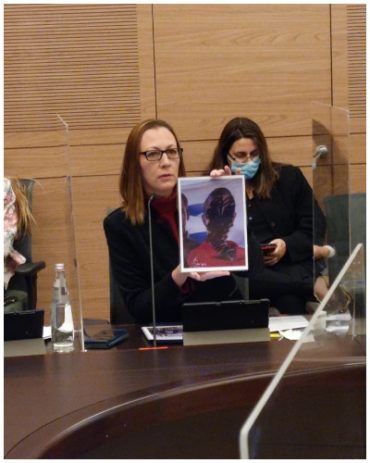 ח"כ יוליה מלינובסקי מציגה תמונות נשים שהושחתו בוועדת הכנסת (צילום: פרטי)