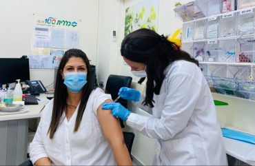האחות גילה ניסנקרן מחסנת את נעמה ארז, מנהלת אדמיניסטרטיבית במרפאת כללית בית וגן (צילום: דוברות כללית)