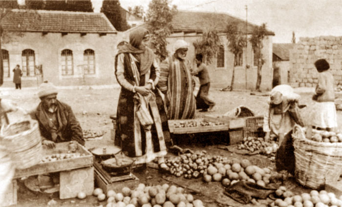 שוק מחנה יהודה בימיו הראשונים (צילום: עבודת צבע ושיפוץ של צילום ממקור לא ידוע בראשית המאה ה-20, תמר הירדני-מתוך ויקפדיה)