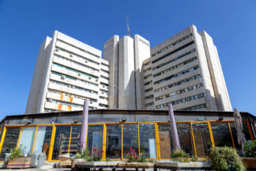 מרפסת על רקע בניין כלל (צילום: נוגה לוי)