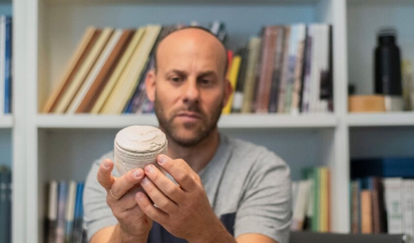 ד"ר איתן קליין מחזיק גרעין של כלי אבן בן 2000 שנה (צילום: יולי שוורץ)