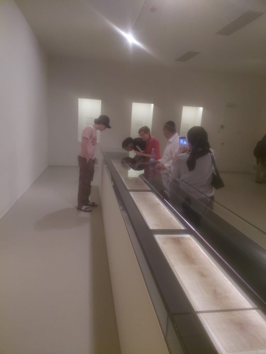 מבקרים צופים בהגדלה של המגילה בתערוכה (צילום: אדם אקרמן)